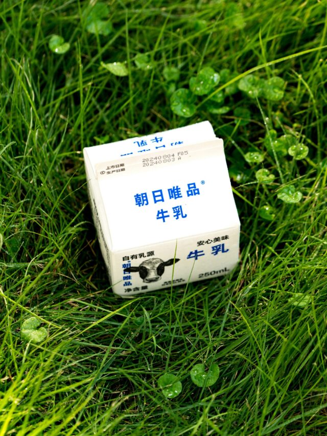 A white box sitting on top of a lush green field