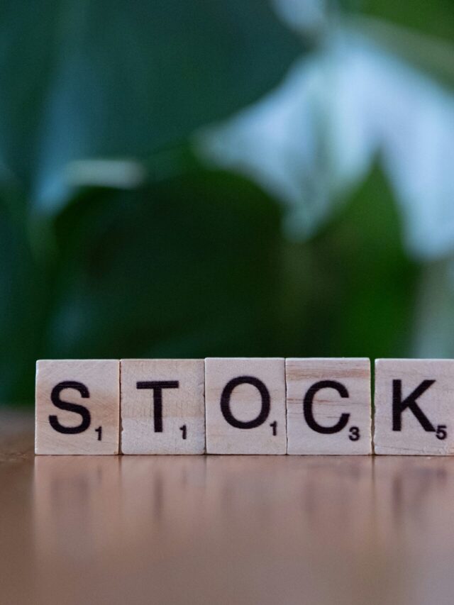 A wooden block spelling the word stock on a table
