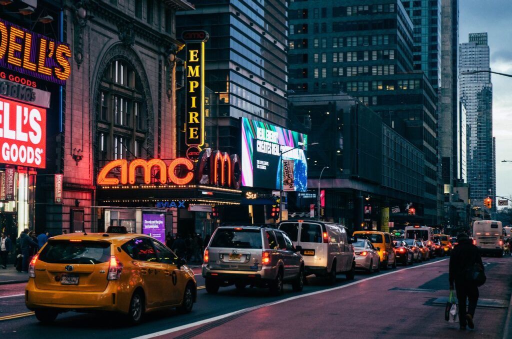 Yellow taxis and neon lights in Times Square, New York City at dusk.