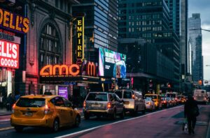 Yellow taxis and neon lights in Times Square, New York City at dusk.