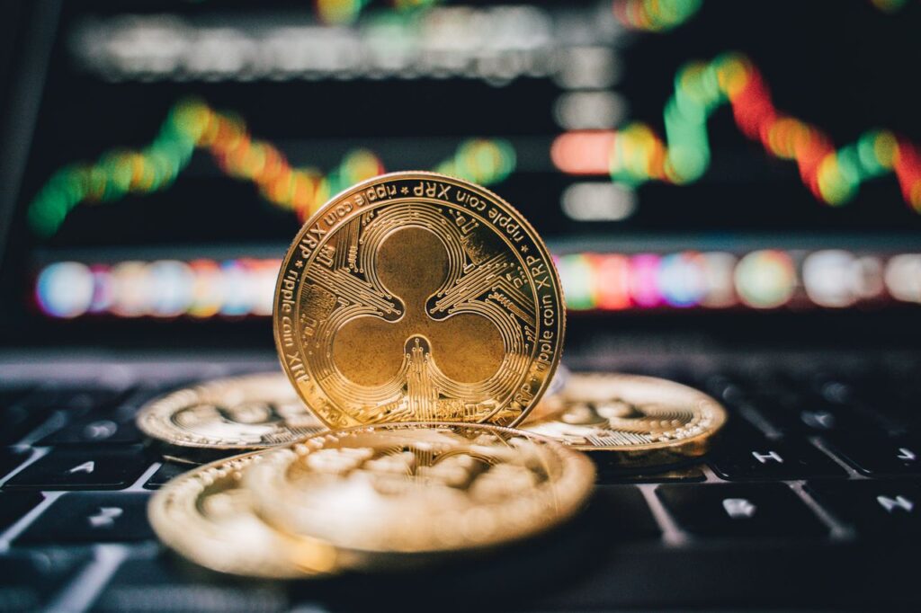 XRP (Ripple) Price Prediction 2025–2030 Golden Ripple XRP coins on laptop, symbolizing cryptocurrency trends and online trading.