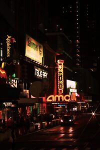 Stock Trumala | Stock Market insights | Financial Education Colorful city scene at night featuring neon lights and busy sidewalks.